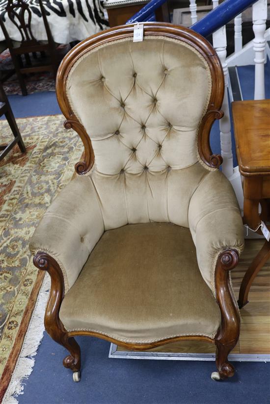 A Victorian mahogany-framed armchair with scrolled terminals, deep-buttoned beige upholstery